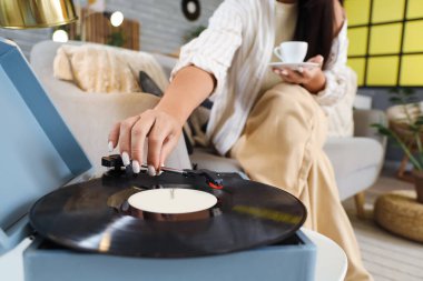 Evde kahve fincanı ve pikabı olan genç bir kadın, yakın plan.