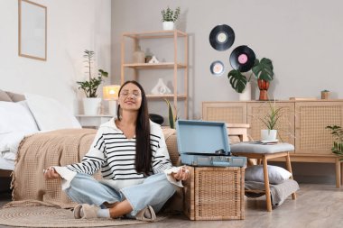 Yatak odasında meditasyon yapan güzel bir kadın.