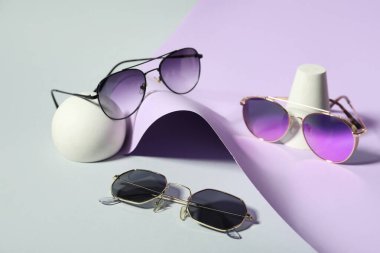 Renkli arka planda farklı stil güneş gözlüklü dekoratif podyumlar