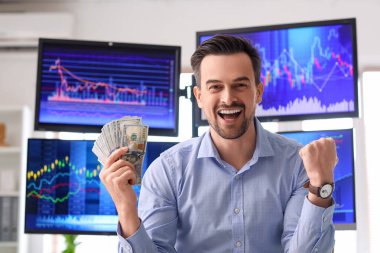 Ofisinde dolar banknotları olan mutlu bir erkek tüccar.