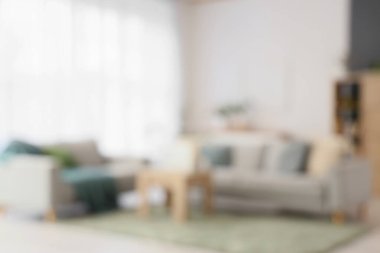 Gri kanepeleri ve masası olan oturma odasının bulanık görüntüsü