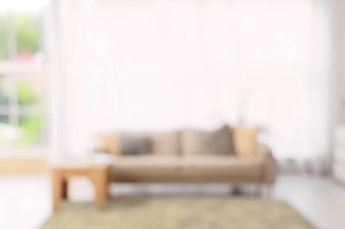 Gri kanepeli, masalı ve pencereli oturma odasının bulanık görüntüsü