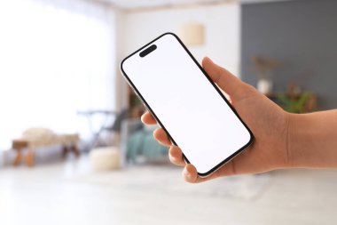 Evde boş cep telefonu olan bir kadın, yakın plan.