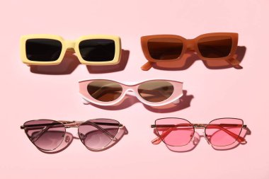 Pembe arka planda farklı bir güneş gözlüğü.