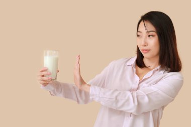 Bej arka planda laktoz toleransı olmayan genç Asyalı kadın.