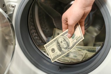 Çamaşır makinesinin yanında dolar banknotları olan kadın, yakın plan.