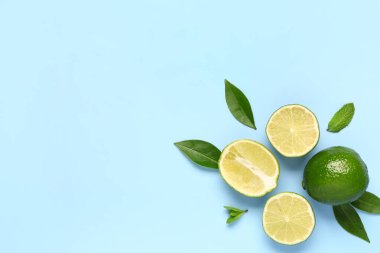 Mavi arka planda yaprakları olan taze limon dilimleri
