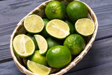 Mavi ahşap arka planda taze limonlu hasır kase.