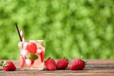 Dışarıdaki ahşap masada çilekli limonata.