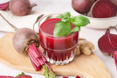 Hafif arka planda bir bardak taze pancar suyu.