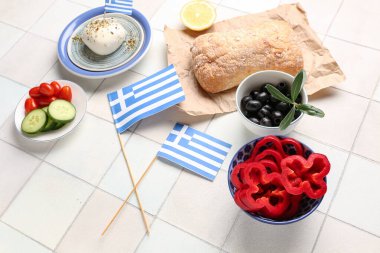 Yunanistan bayrakları ve fayanslı masada farklı yiyecekler