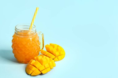 Mason kavanozu mavi arka planda taze mango suyu.