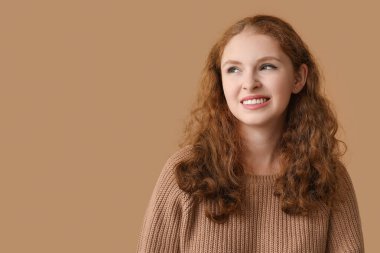 Kahverengi arka planda utanmış genç bir kadının portresi.