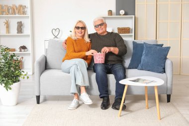 Üç boyutlu gözlüklü, patlamış mısırlı ve evdeki kanepede film izleyen olgun bir çift.