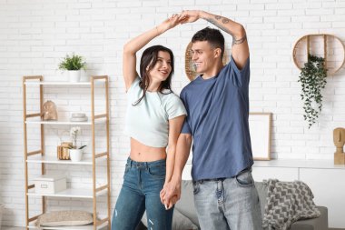 Güzel genç çift evde dans ediyor.