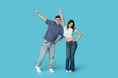 Mavi arka planda dans eden mutlu genç çift