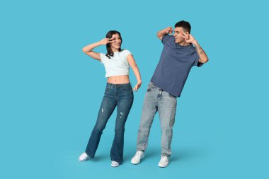 Mavi arka planda dans eden mutlu genç çift