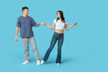 Mavi arka planda dans eden mutlu genç çift