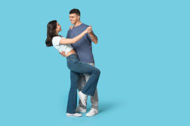 Mavi arka planda dans eden güzel genç çift