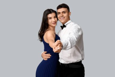 Gri arka planda dans eden güzel genç çift