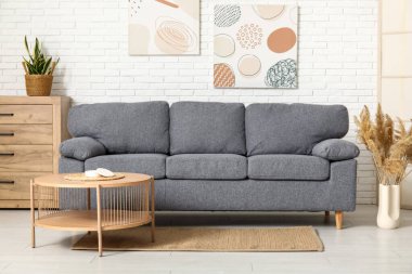 İçinde rahat bir kanepe, resimler, çekmeceler ve kahve masası olan güzel bir oturma odası.