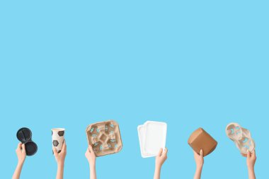 Mavi arka planda farklı çöpleri tutan kadın eller. Geri dönüşüm kavramı