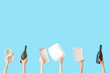 Mavi arka planda farklı çöpleri tutan kadın eller. Geri dönüşüm kavramı