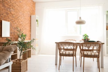 Odanın içinde ahşap masa, sandalyeler ve asılı lamba var.