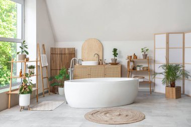 Katlanan ekran, küvet ve çiçekli hafif banyo.