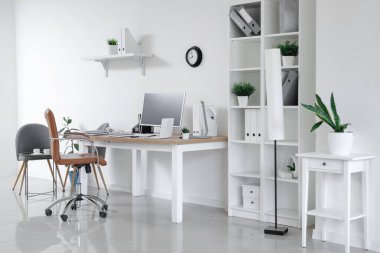 Çalışma yeri, modern bilgisayar, raf ünitesi ve koltuğu olan şık bir ofis.