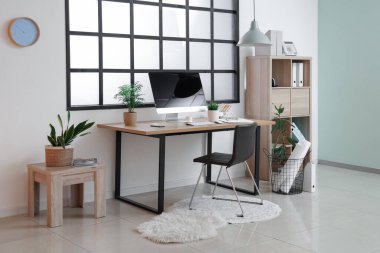 Çalışma yeri, modern bilgisayar, raf ünitesi ve koltuğu olan güzel bir ofis.