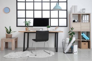 Çalışma yeri, modern bilgisayar, raf ünitesi ve koltuğu olan güzel bir ofis.