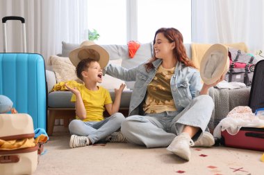 Mutlu anne ve küçük oğlu seyahat etmeden önce yazlık şapkalar deniyorlar.