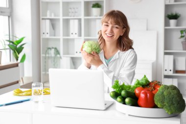 Ofisinde lahana olan kadın beslenme uzmanı.