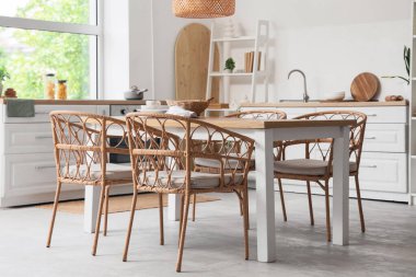 Açık mutfakta hasır sandalyeli yemek masası.