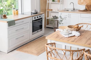 Mutfağın içinde yemek masası ve tezgahları var.