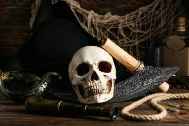 Kılıçlı kafatası, dürbünlü dürbün ve ahşap masada ip. Korsan konsepti
