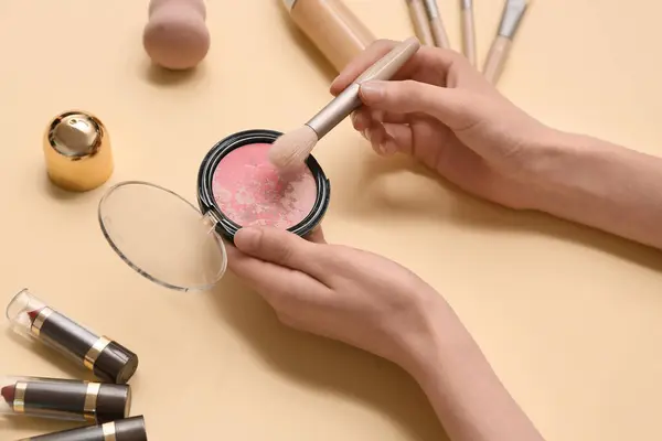 stock image Female hands with blush and different cosmetic products on color background, closeup