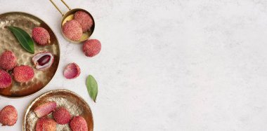 Açık arkaplanda lezzetli litchi meyveli tabaklar ve metin için boşluk