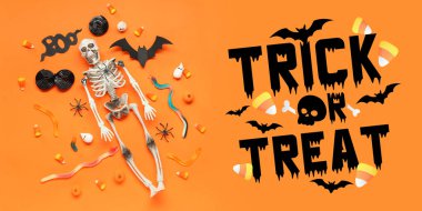 Cadılar Bayramı için afiş, süslemeler ve turuncu arka planda farklı tatlılar