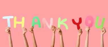Kelimelerle eller pembe arka planda teşekkürler