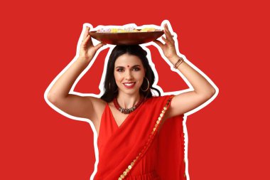 Kırmızı arka planda mumları ve çiçekleri olan güzel bir Hintli kadın. Divaly kutlaması