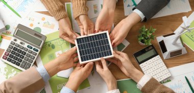 Ofisteki toplantı sırasında güneş paneli olan bir iş ekibi. Yeşil enerji kavramı