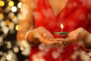 Beautiful Indian woman with diya lamp, closeup. Divaly celebration clipart