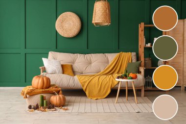 Oturma odasının içinde sonbahar dekoru olan rahat bir kanepe ve masa. Farklı renk desenleri