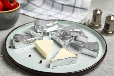 Gri arkaplanda lezzetli işlenmiş peynir üçgenleri olan tabak.