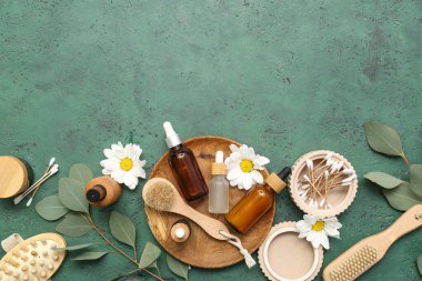 Renkli arka planda kozmetik ürünleri, banyo malzemeleri ve çiçeklerle kompozisyon