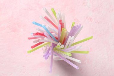 Grunge pembe arka planda farklı renkli pipetlere sahip cam