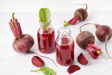 Hafif arka planda taze pancar suyu ve sebze şişeleri