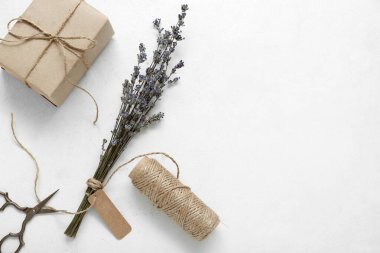 Beyaz grunge arka planında makas, iplik ve kurutulmuş lavanta ile bağlanmış kutu